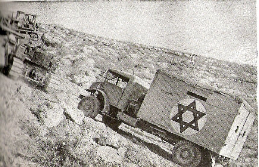 1948년 6월 버마 로드에서 불도저가 트럭을 견인하는 흑백 사진.