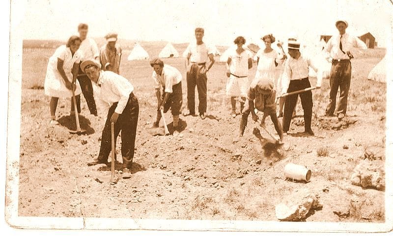 부두 근처에 도착한 유대인 이민자들이 짐을 들고 서 있는 1920년대 흑백 사진.